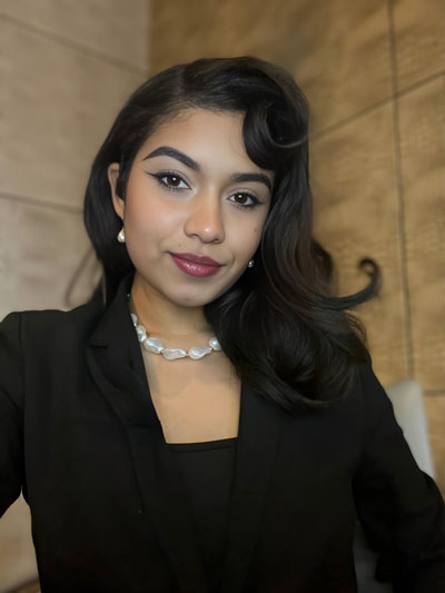 A brown Puerto Rican woman with Dark hair and black blazer